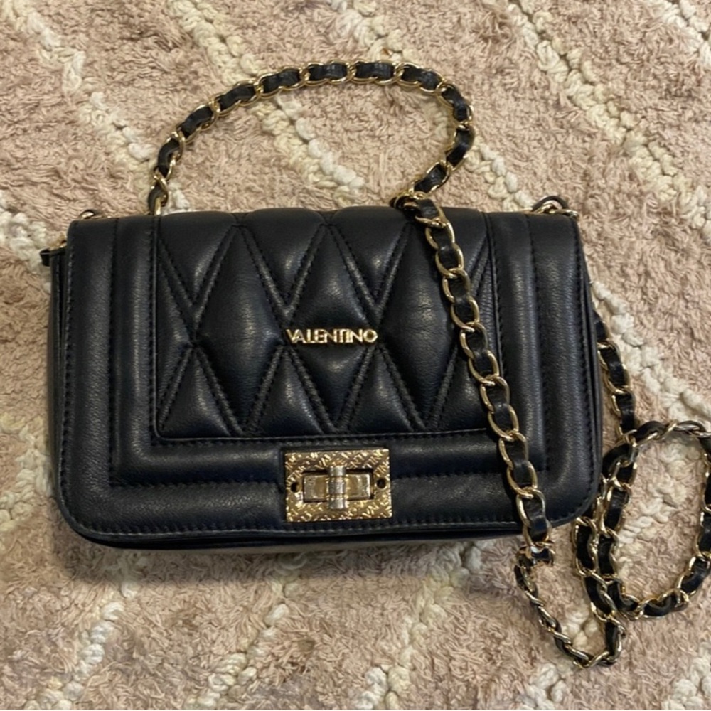 Mario Valentino bag crafted from smooth leather with gleaming hardware finishes.